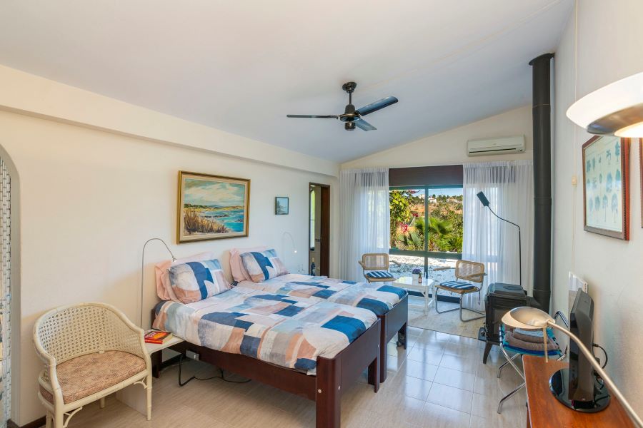 Master bedroom with TV channels, air conditioning, romantic wood burner and sliding doors to the garden with private pool