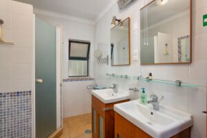 Family bathroom with two sinks, toilet and shower. For the winter visitors with a dog to heat with a radiant heater.